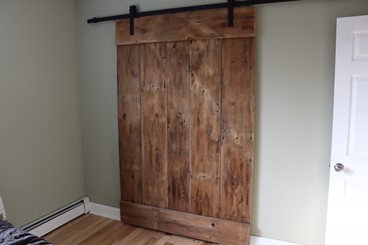 Sliding reclaimed barnwood door in home